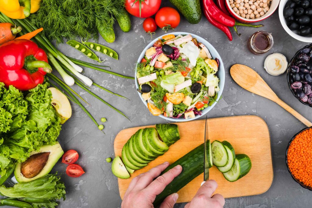 Blick auf die Zubereitung eines bunten Salates: so sieht gesunde Ernährung aus!